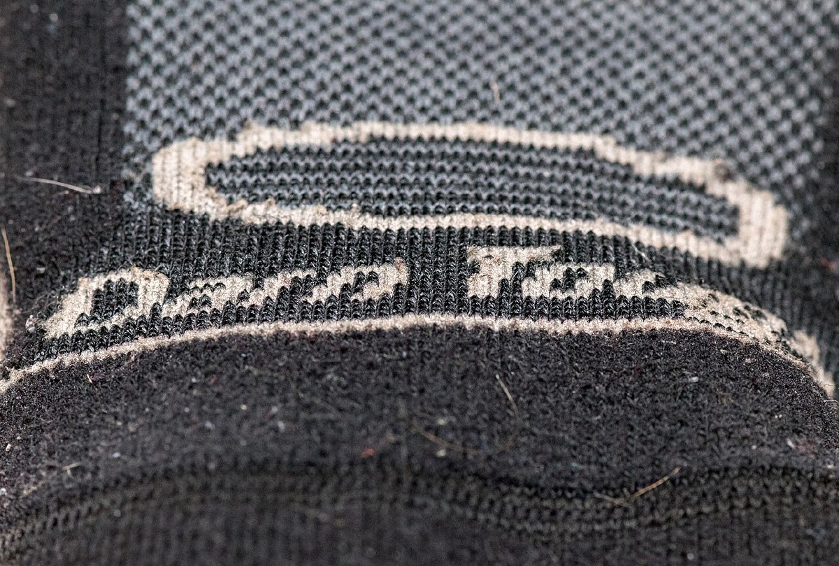 Macro closeup of a Darn Tough merino sock showing the high-density knit and the knitted logo band