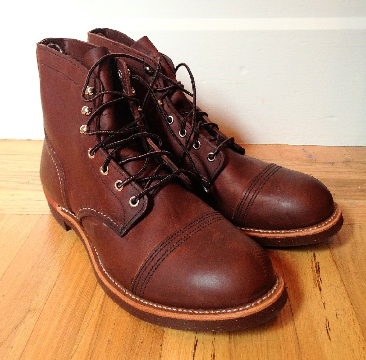 Pair of Red Wing Iron Ranger boots in amber leather, showing the cap toes, brass speed hooks, and Goodyear welt stitching